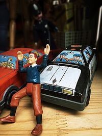 Close-up of figurine and toy cars on table