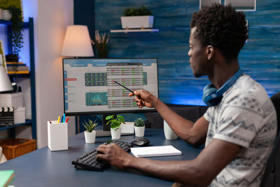 Man using mobile phone while sitting on table