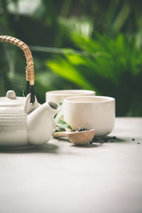 Close-up of teapot and cup on table