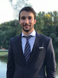 Portrait of businessman standing against lake and trees