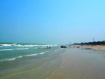 Scenic view of beach against clear blue sky