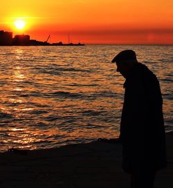 Silhouette of people in sea at sunset