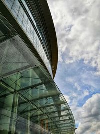 Low angle view of modern building against cloudy sky