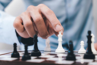 Midsection of man playing chess