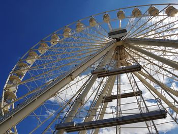 Low angle view of ferris wheel against blue sky