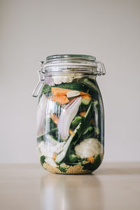 Healthy salad with veggies and quinoa in jar on table