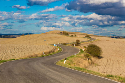 Empty road along countryside landscape