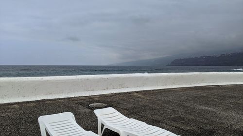 Low section of person on beach against sky