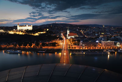 High angle view of illuminated buildings by river in city at night