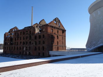 Old building against clear blue sky during winter