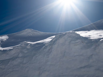 Scenic view of snowcapped mountains against sky on sunny day