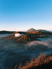 Scenic view of volcanoes against clear blue sky