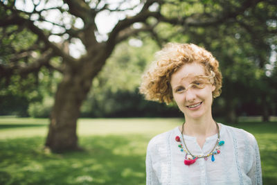 Portrait of smiling mid adult woman standing in park