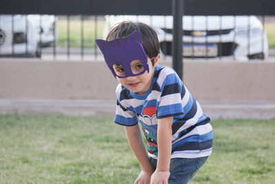 Portrait of boy wearing eye mask on field