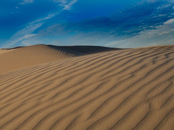 Sand dunes in desert against sky