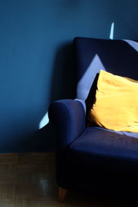 Close-up of sofa against blue wall at home