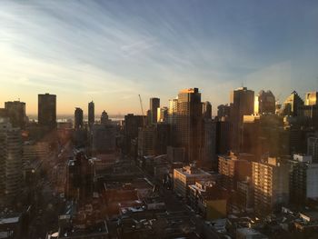 Aerial view of buildings in city against sky during sunset