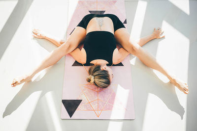 High angle view of woman with arms raised on floor