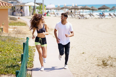 Full length of couple running on beach