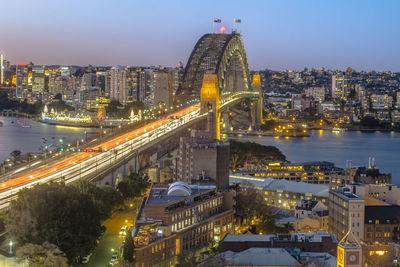 Illuminated cityscape against sky at dusk