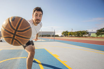 Full length of man playing with ball against sky