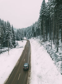 Car on road amidst trees during winter