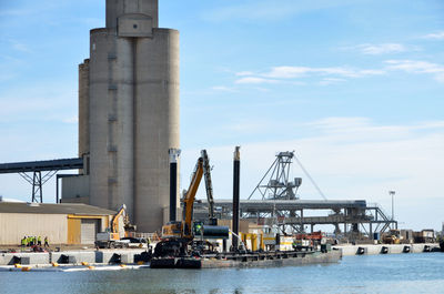 Commercial dock by sea against sky