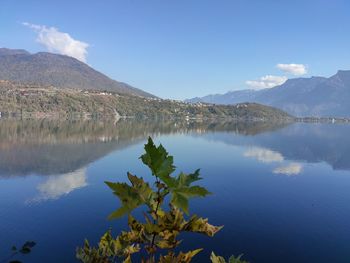 Scenic view of lake by mountains against sky