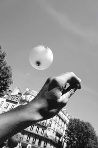 Low angle view of cropped hand against sky