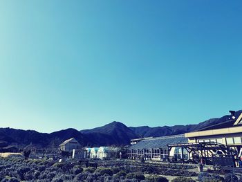 Houses against mountains against clear blue sky