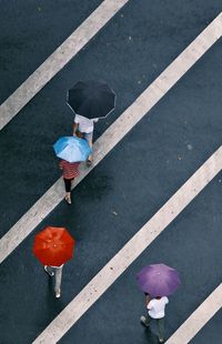 High angle view of person with umbrella walking on road