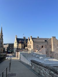 Buildings in city against clear blue sky