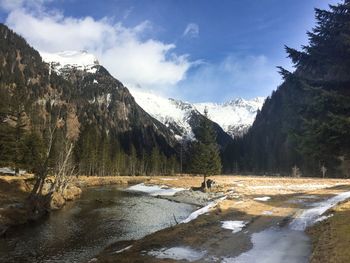 Scenic view of lake by mountains against sky