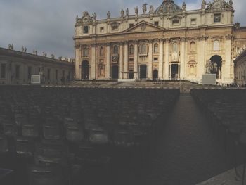 Statue in city against sky