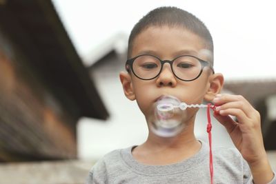 Portrait of smiling boy holding eyeglasses