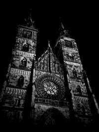 Low angle view of clock tower at night