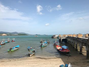 Boats moored on beach against sky