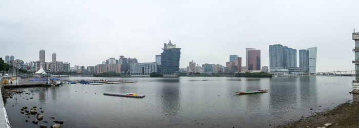 Boats in river with city in background