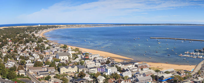 High angle view of city by sea against blue sky