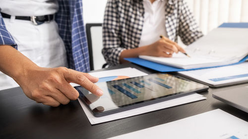 Midsection of man using laptop on table