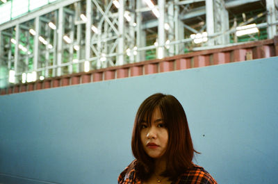 Portrait of young woman against wall