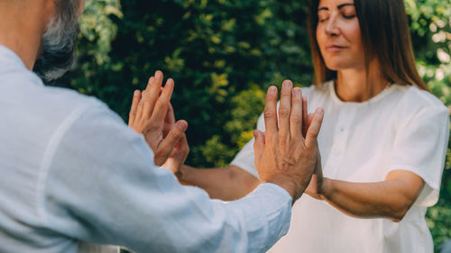 Close up image of instructors and womans hands. reiki healing course, energy 