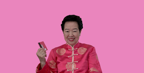 Portrait of a smiling young man against pink background