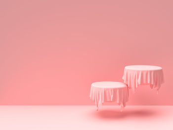 Close-up of empty table against pink background