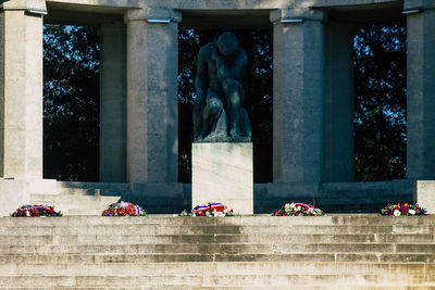 View of flowers on steps against statue