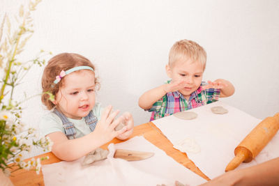 Cute siblings playing with clay at home