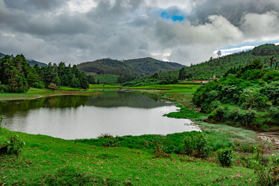 Scenic view of lake by trees against sky