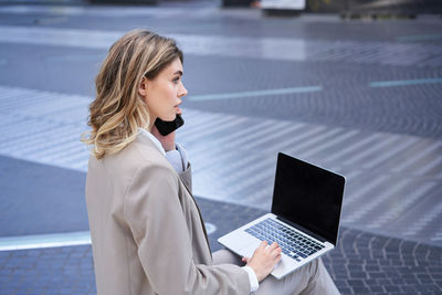 Young woman using laptop while sitting at office