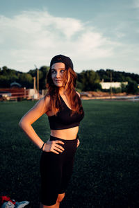 Portrait of young woman standing against sky