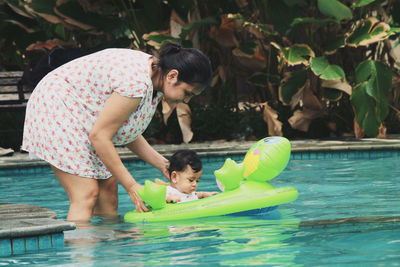 Full length of siblings in swimming pool